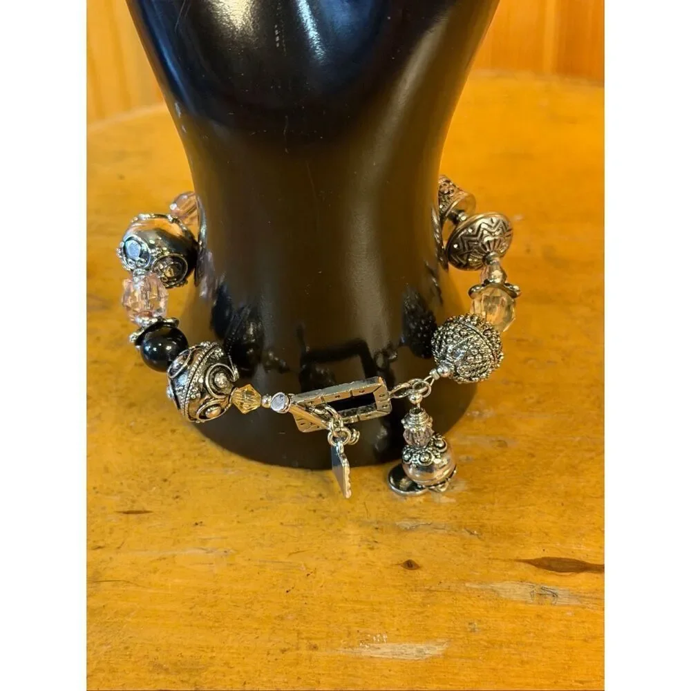 charm bracelet featuring a variety of intricate metal beads, clear and black (74